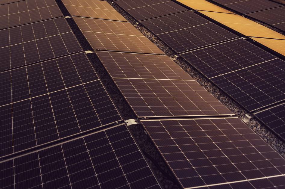 Close-up of hands analyzing a string inverter connected to solar panels