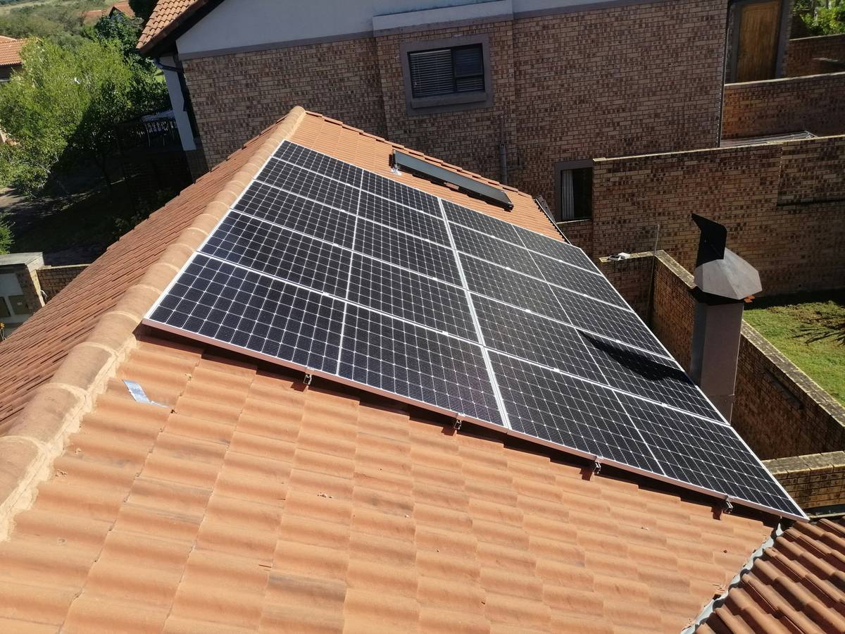 string inverters for solar panels mounted on a garage wall with wiring connected to rooftop PV array