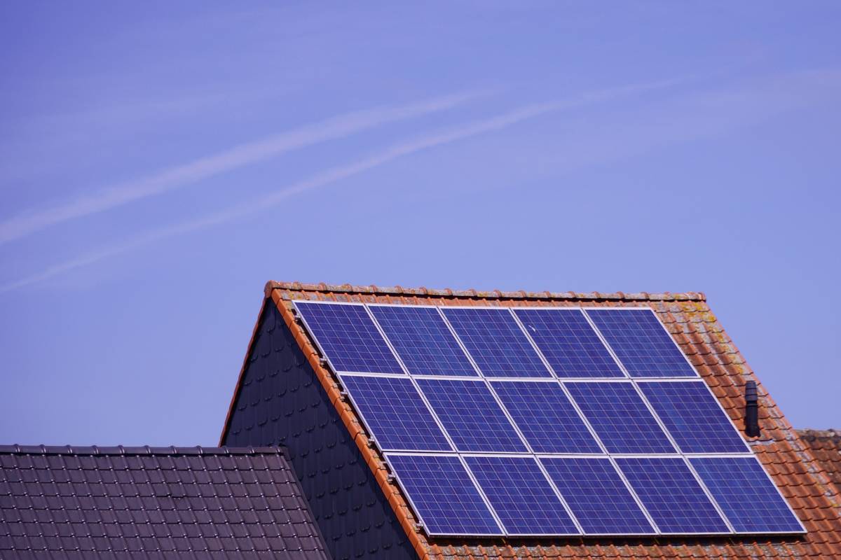 Side-by-side comparison of string inverter and central inverter mounted on residential solar installations